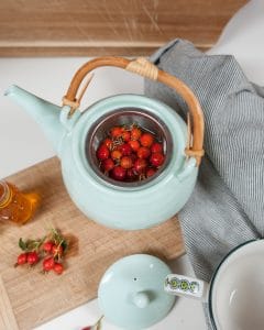 Brewing wild rose hip tea with fresh whole rose hips.