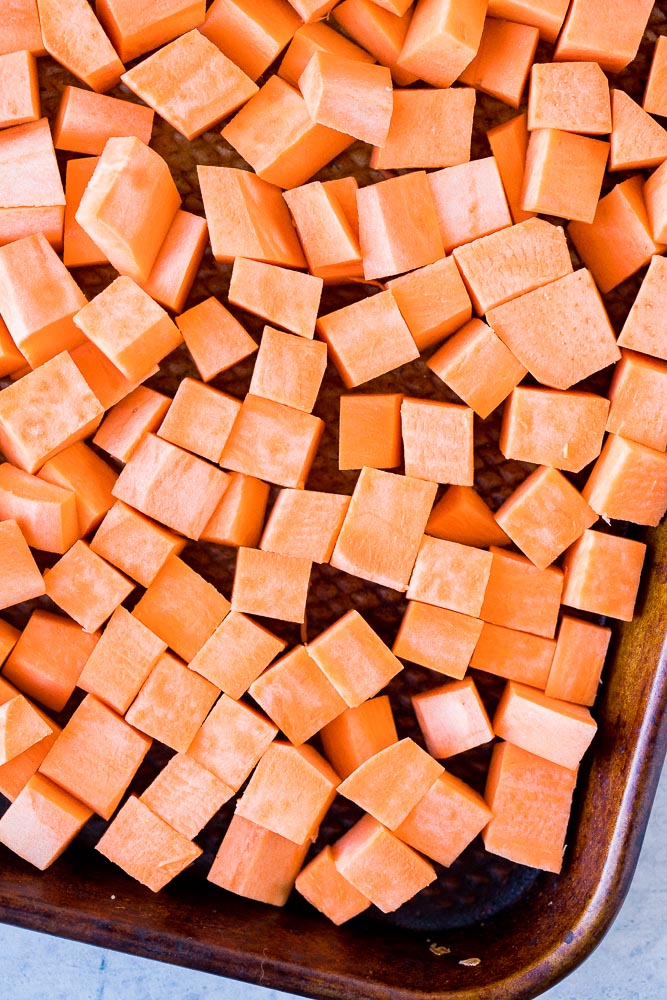 Diced sweet potatoes on a baking tray ready to be roasted